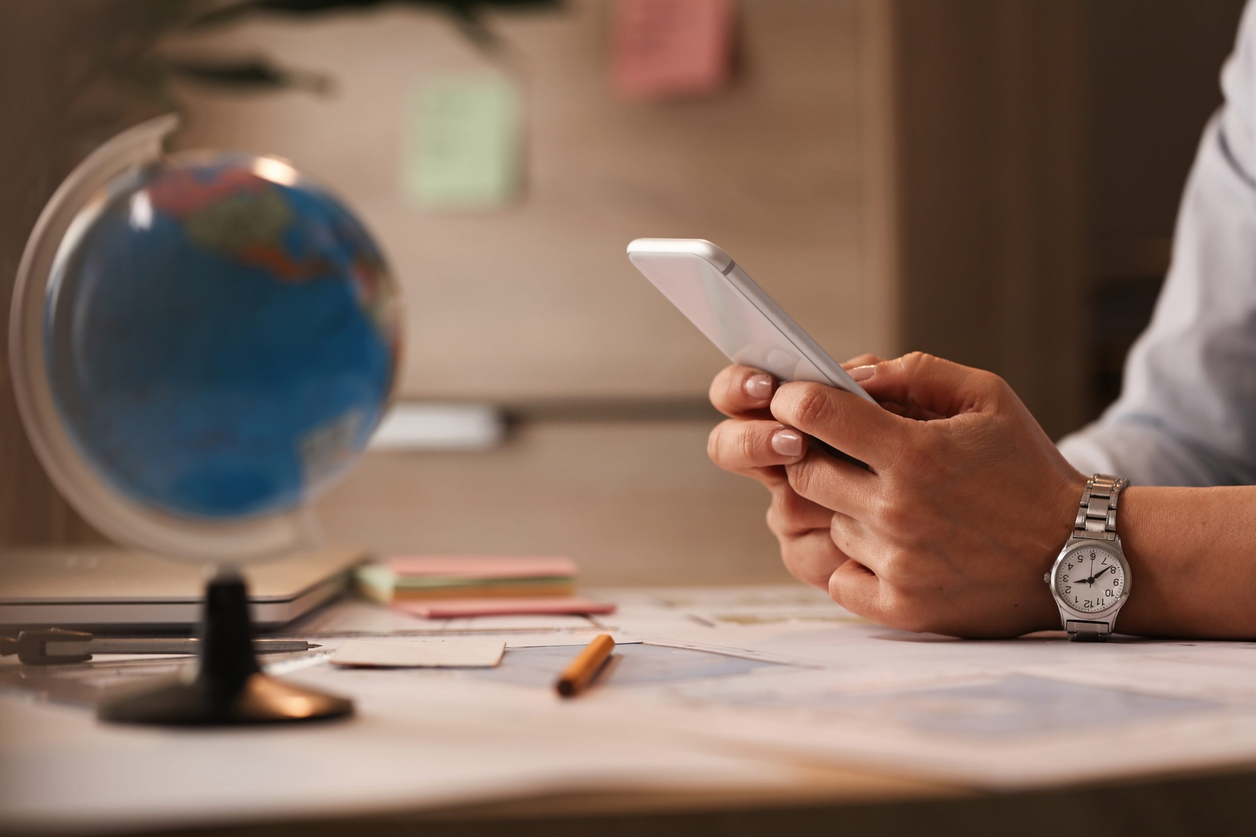 Close up of businesswoman using smart phone and typing a message in the office.