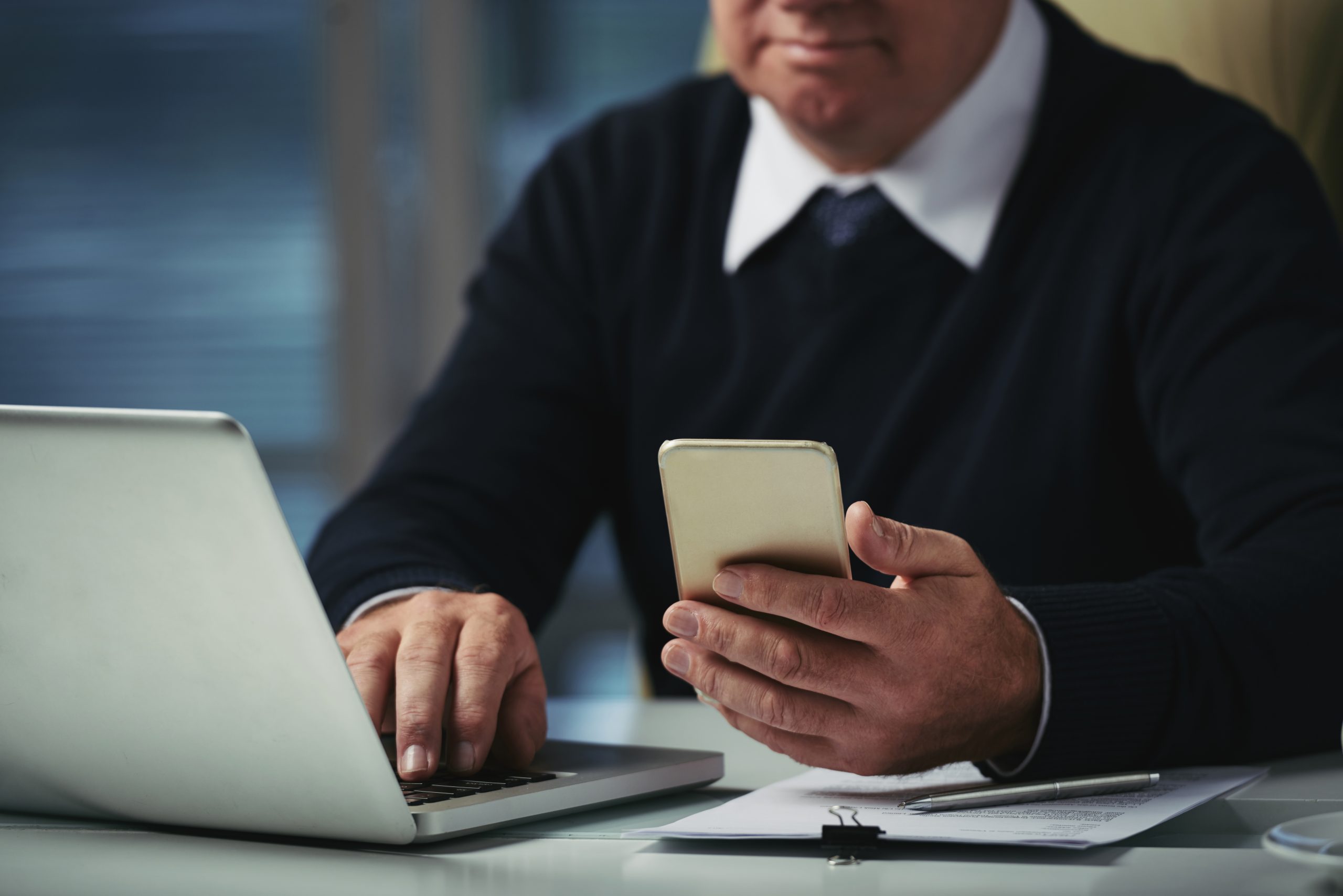 Cropped image of businesman reading messages on smartphone screen