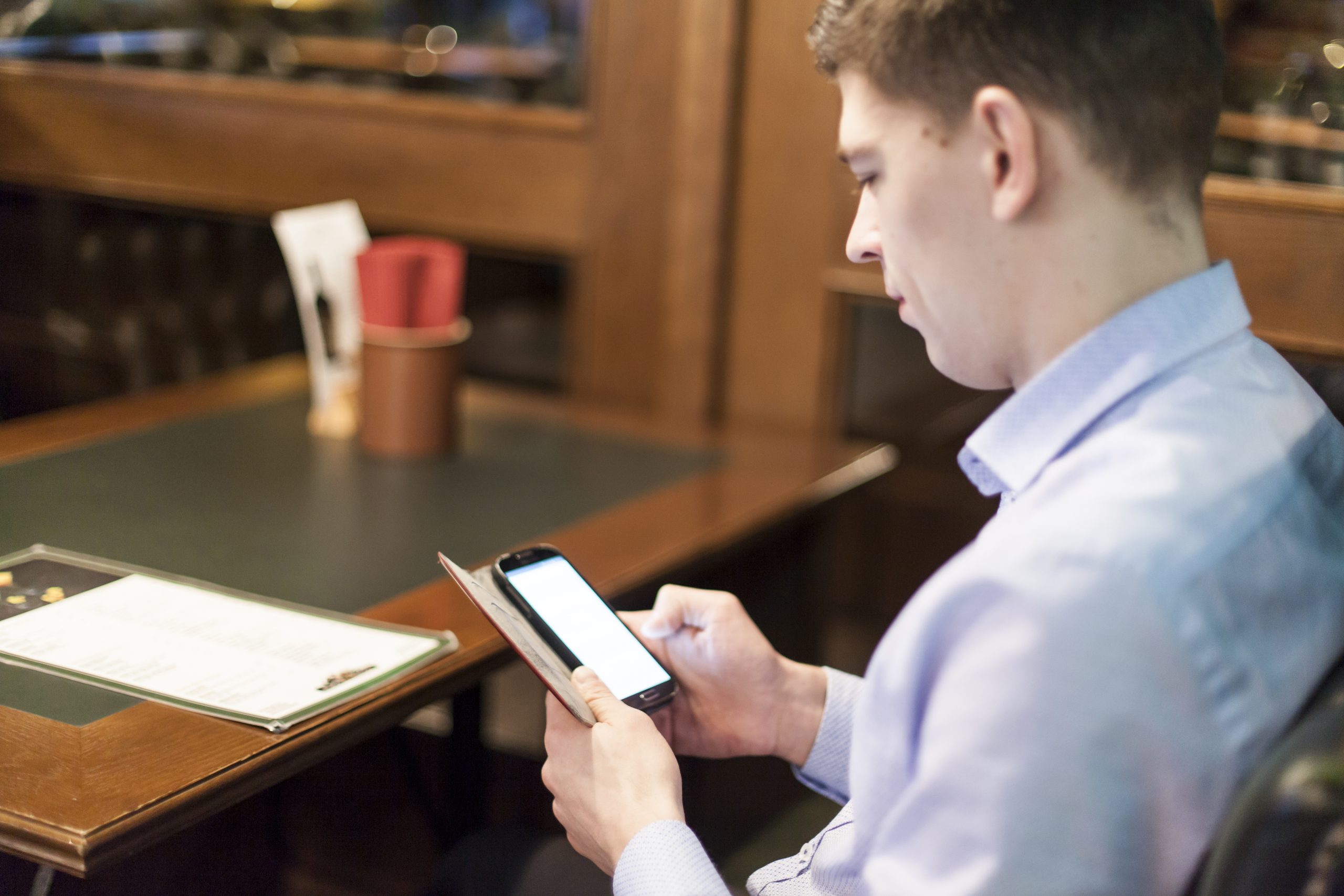 man-browsing-smartphone-restaurant